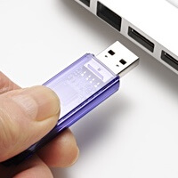 [image: USB Drive being inserted into Laptop]